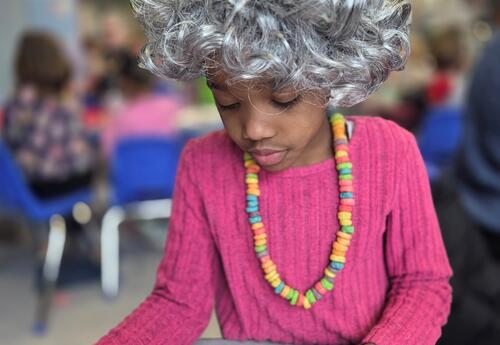 A kindergartener is dressed up like a senior citizen.