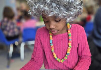 A kindergartener is dressed up like a senior citizen.