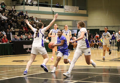 Photo of student-athlete on the girls' team bringing the ball down the court at the semifinal game