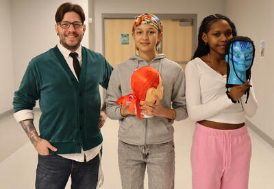 Cosmetology teacher with two students with their mannequin head projects