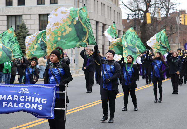 Photograph of student-musicians and color guard marching at the St. Patrick's Day parade