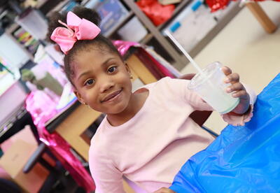 A student sips on a green milk shake.