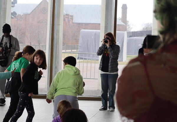 Elementary students create body art for high school students to photograph.