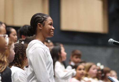 Elementary chorus student standing at the microphone