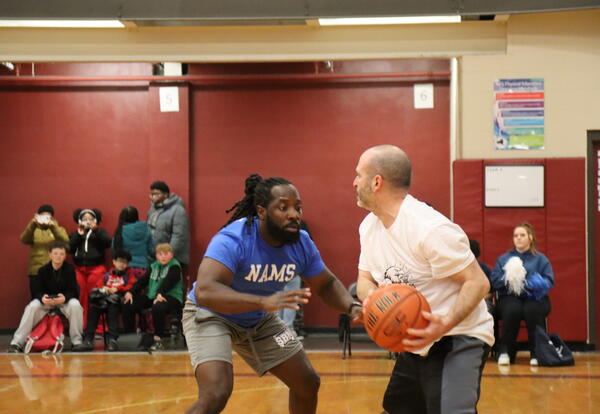 Two administrators play basketball together in a fundraiser game.