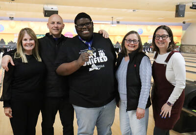 Unified bowling student-athlete posing with district staff