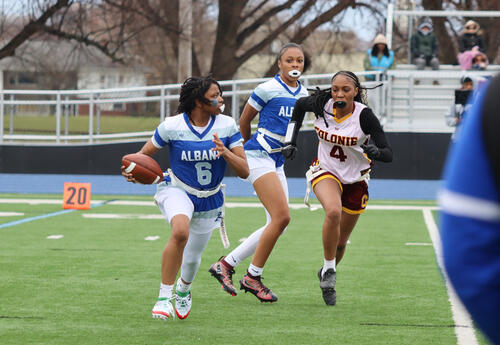 Narai Danzy running with the ball with Aasett Taylor in the background