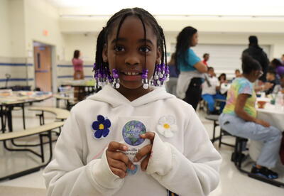 student holding earth day packet
