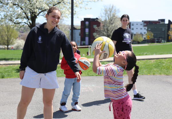 UAlbany basketball players help students learn to play the sport.