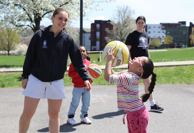 UAlbany basketball players help students learn to play the sport.