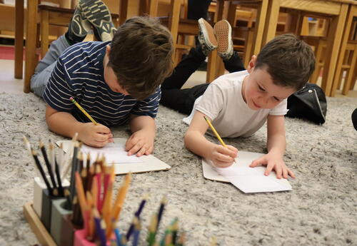 Two students write thank you cards for their bus drivers.