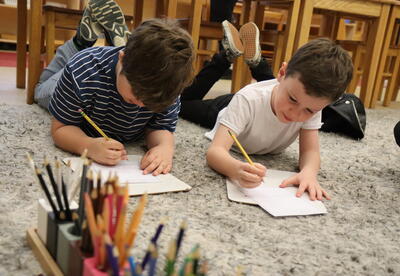 Two students write thank you cards for their bus drivers.