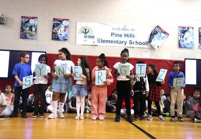 Students spell out the word synergize during an assembly.
