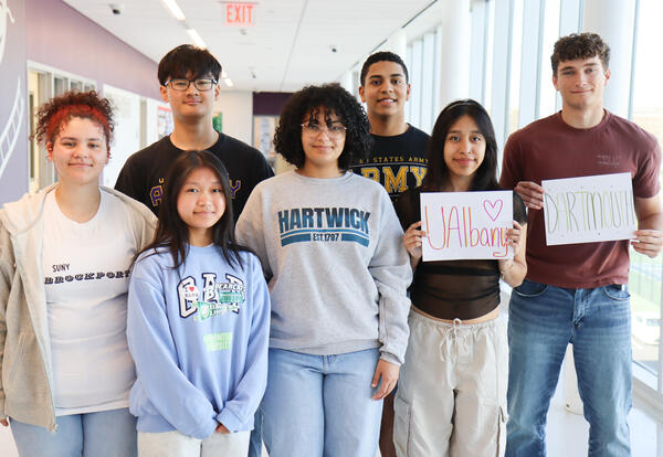 Group of students posing for a photo in their college shirts