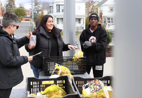City Gardener Jena DiTonno with teammate handing out bulbs to students