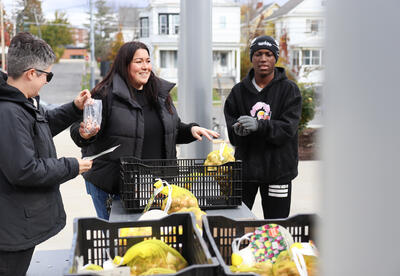 City Gardener Jena DiTonno with teammate handing out bulbs to students