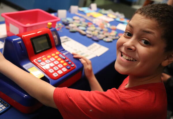 A student works a cash register at a school store.