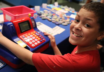 A student works a cash register at a school store.
