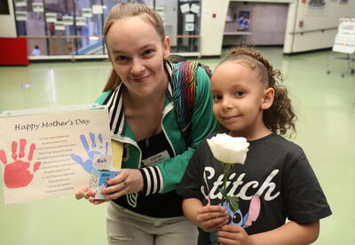 A mom and daughter pose during a Mother's Day celebration.