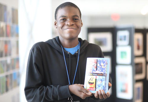 Student posing with artwork