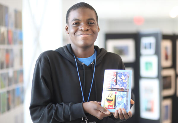 Student posing with artwork