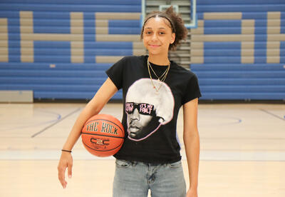 Headshot of Aaliyah Douglas holding a basketball in �鶹Ӱ�� High gym