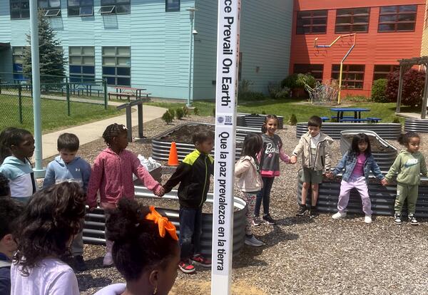 Students celebrate the installation of a peace pole on the Montessori playground.