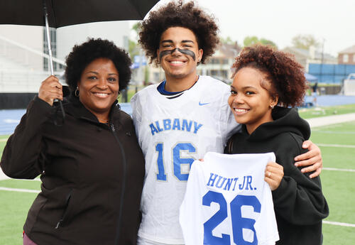 Derek Hunt Jr. with loved ones on the turf field