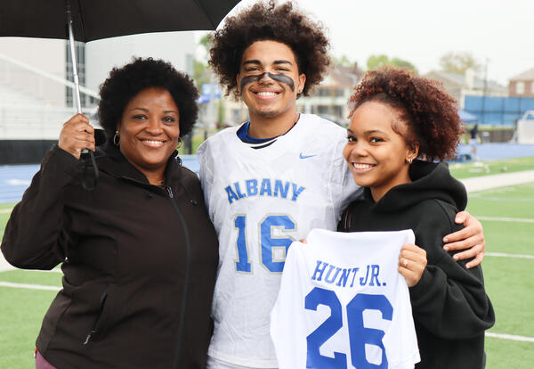 Derek Hunt Jr. with loved ones on the turf field
