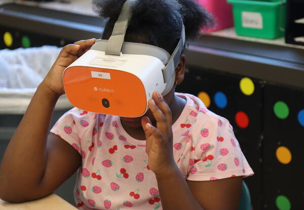 A student learns about wildlife using virtual reality goggles.