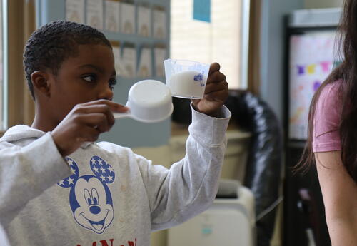 A student measures sugar for a recipe