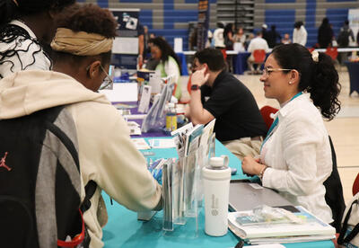 Students speaking with a representatives at a table