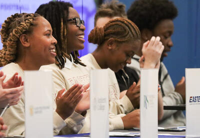 Students seated at the table during the signing ceremony
