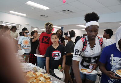 Students wait in line for a BBQ at school.