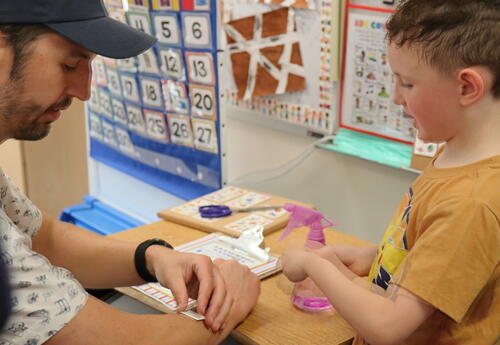 A father and son apply temporary tattoos.
