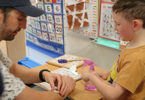 A father and son apply temporary tattoos.