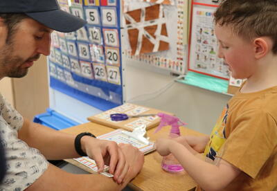 A father and son apply temporary tattoos.