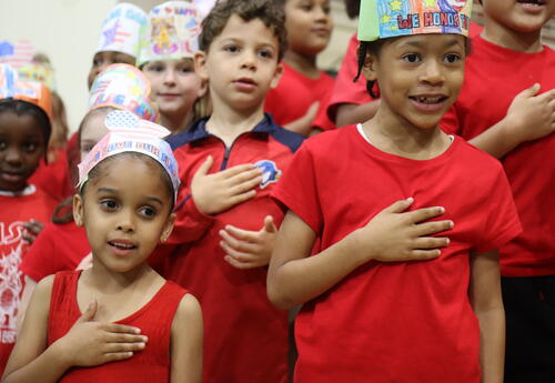 Students recite the Pledge of Allegiance during a Flag Day celebration.