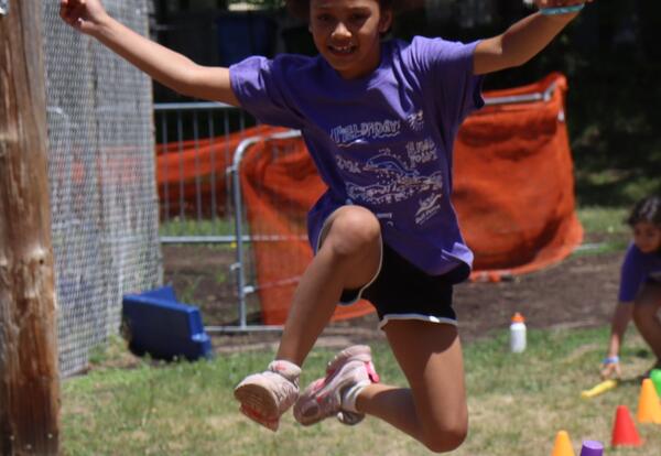 A student jumps over a hurdle during Field Day.