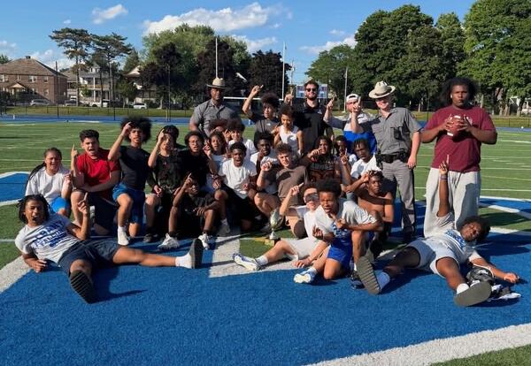 A modified football team poses for a picture on the turf field.