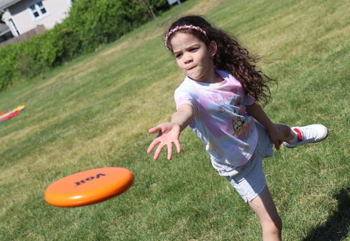 A student throws a frisbee during field day.