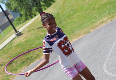 A student uses a hula hoop during a field day.