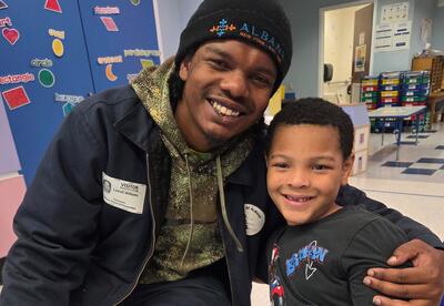 A father and his son pose at a Father's Day event.