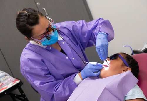 A student receives a dental cleaning thanks to a community partner.