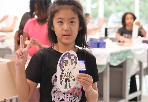 A Montessori Magnet School students displays her art work.