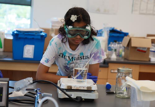 A student conducts a science lab during summer camp.