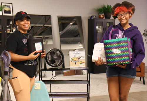 A family member and student posing with college essentials items