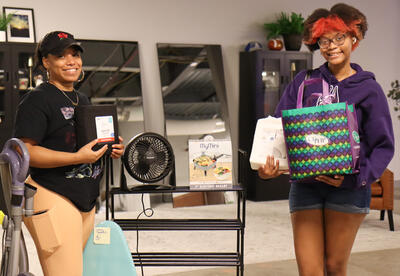 A family member and student posing with college essentials items