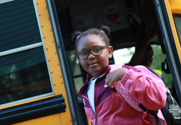 A students exits the bus on the first day of school.