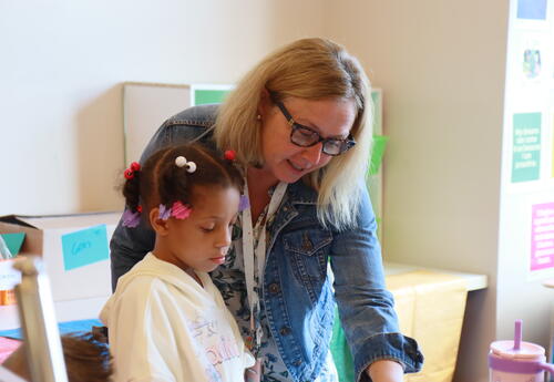 A teacher assists a student with an assignment.